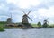 Three waterfront Dutch windmills against the cloudy sky, Netherlands