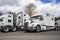 Three white big rigs semi trucks tractors without semi trailers and different cab lengths for a comfortable rest of the truck