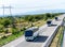 Three white buses in line on a country highway