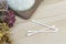 Three white cotton bud are placed next to dried flowers. on a light wood background Prepared for use in cleaning the ear canal or