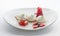 Three white icecream balls with berries on white dish