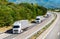 Three white Lorry trucks in line on a country highway