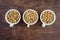 Three white single serving bowls with blackberry crumble dessert, on a wood background