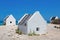 Three white slave houses on beach near sea