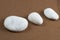 Three White Stones on Brown Sand