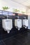 Three white urinals in men bathroom