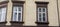 Three white windows on the beige facade of the house