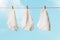 Three white women`s panties on a clothesline against a blue sky.