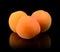 Three whole apricots isolated on blac
