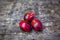 Three whole nutmeg red placenta-like cover of seed on wooden background.