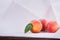 Three whole and red peaches with green leaves on a white background. Healthful and organic delicious fruit. Summer breakfast.