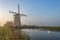 Three wind mills of Molendriegang Leidschendam, Netherlands during a misty Sunrise with a Swan on the foreground