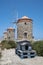 Three Windmills on the Rhodes\\\' Harbor and Elevated Cat Houses in the Foreground for the Area\\\'s Stray Cats