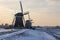 The three windmills in a row during sunrise on a cold winter morning with a snowy landscape at the three windmills in Leidschendam