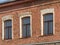 Three windows of the old mansion 19 century with brown bricks wall