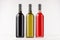 Three wine bottles different colors on white wooden board, mock up.