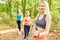 Three women as a hiking group doing Nordic Walking