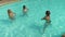 Three women doing fitness exercising in the pool water