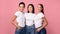 Three Women Embracing Standing In Studio On Pink Background, Panorama