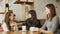 Three women girlfriends in a cafe are talking and drinking their beverages.