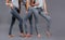 Three women in good form of pop in the legends of Push-Up on a gray background, fashionable advertising advertising space for text