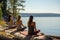 Three Women Meditating By A Tranquil Lake In The Morning Sun