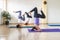 Three women practicing Yoga in a class in salamba sirsasana headstand posture