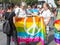 Three women waiving a gay rainbow flag saying `Peace and Love` during the Belgrade Gay Pride