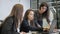 Three women is working, using laptop and talk in modern office.