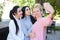 Three wonderful young girl girlfriends make selfie, photo on pho