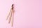 three wooden bamboo toothbrushes on a pink background, top view.  Dental care concept