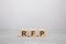 three wooden blocks with the letters RFP on the gray table. business concept