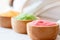 three wooden bowls filled with different colored spa salt for skincare