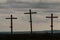 Three Wooden Crosses Stand Against A Dark Ominous Sky