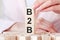 Three wooden cubes with letters B2B - means business to business