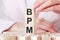 Three wooden cubes with letters BPM - means business process management