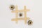 Three wooden gears from the mechanism lie in a row in a line in the game of tic tac toe, in a grid on a white background