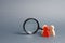 Three wooden human figure stands near a magnifying glass on a gray background. Search for vacancies and work. Human resources