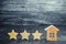 Three wooden stars and a house. Three star hotel or restaurant. Review of the critic. Quality of service and level of service.