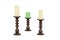 Three wooden vintage candlesticks with a candle on white background