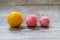 Three wool balls on the wooden background.