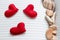 Three woven bright red hearts lying on the page of an open diary or glider in a line with seashells or sea fossils for Valentine`