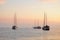 Three yachts at sea at a beautiful sunset