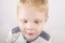 Three-year-old boy with a mouth smeared with cake crumbs on a white background