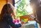 Three year old girl coloring with her mother with watercolors