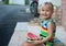 Three-year-old little European girl blonde eating watermelon