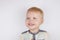 Three-year-old smiling boy with a mouth smeared with cake crumbs on a white background