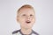 Three-year-old smiling boy with a mouth smeared with cake crumbs on a white background