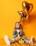 Three years girl toddler kid with gold presents balloons and birthday cap celebrating