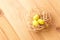 Three yellow eggs in a nest on a light wooden background. Easter celebrate concept